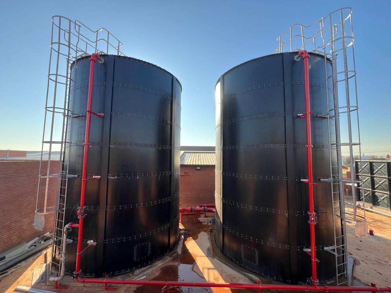 Two Videx cylindrical steel water tanks with access ladders and safety cages at Fleurhof Mall